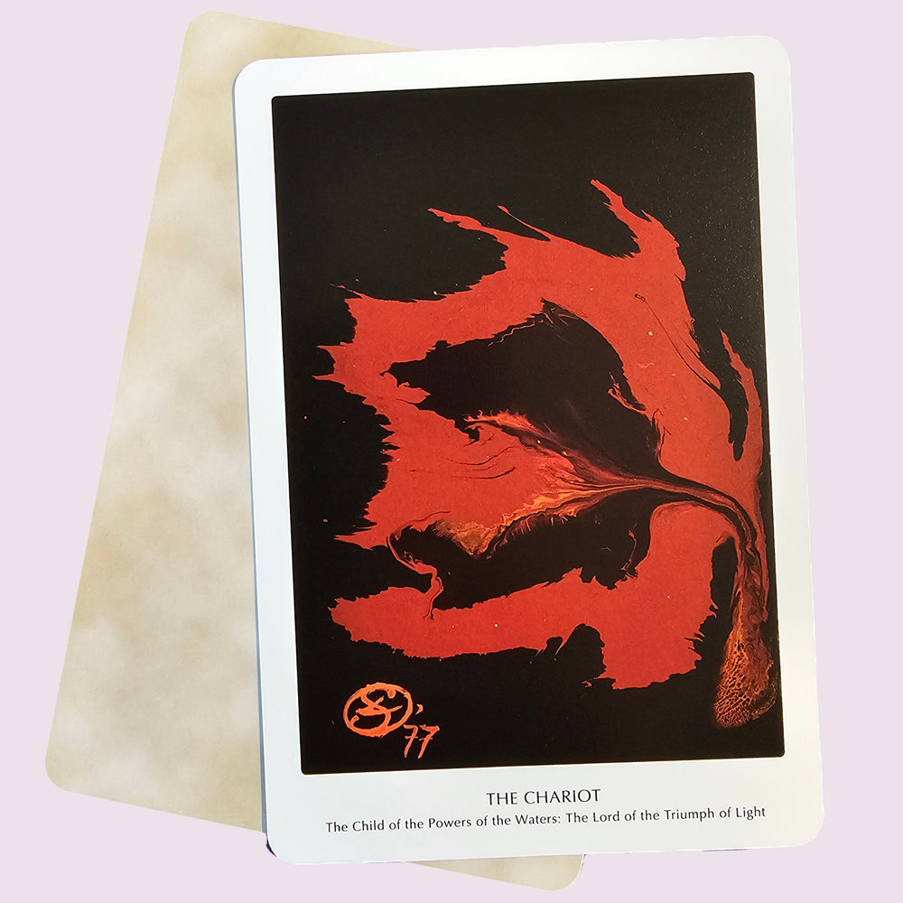 Tarot card titled 'The Chariot' with red and black design on a light pink background