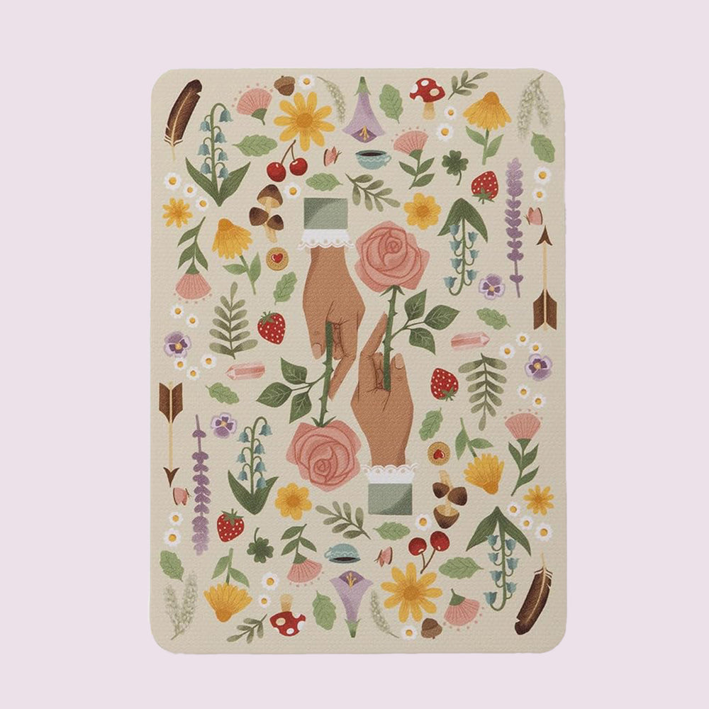 Cottage Magic Tarot card backs featuring illustrated hands holding a rose, surrounded by flowers, herbs, and woodland motifs
