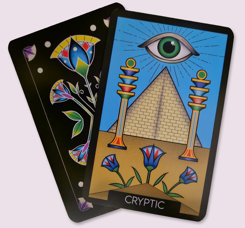 Cryptic card from the Initiates Oracle featuring the all-seeing eye above a pyramid framed by colorful ceremonial pillars and desert flowers