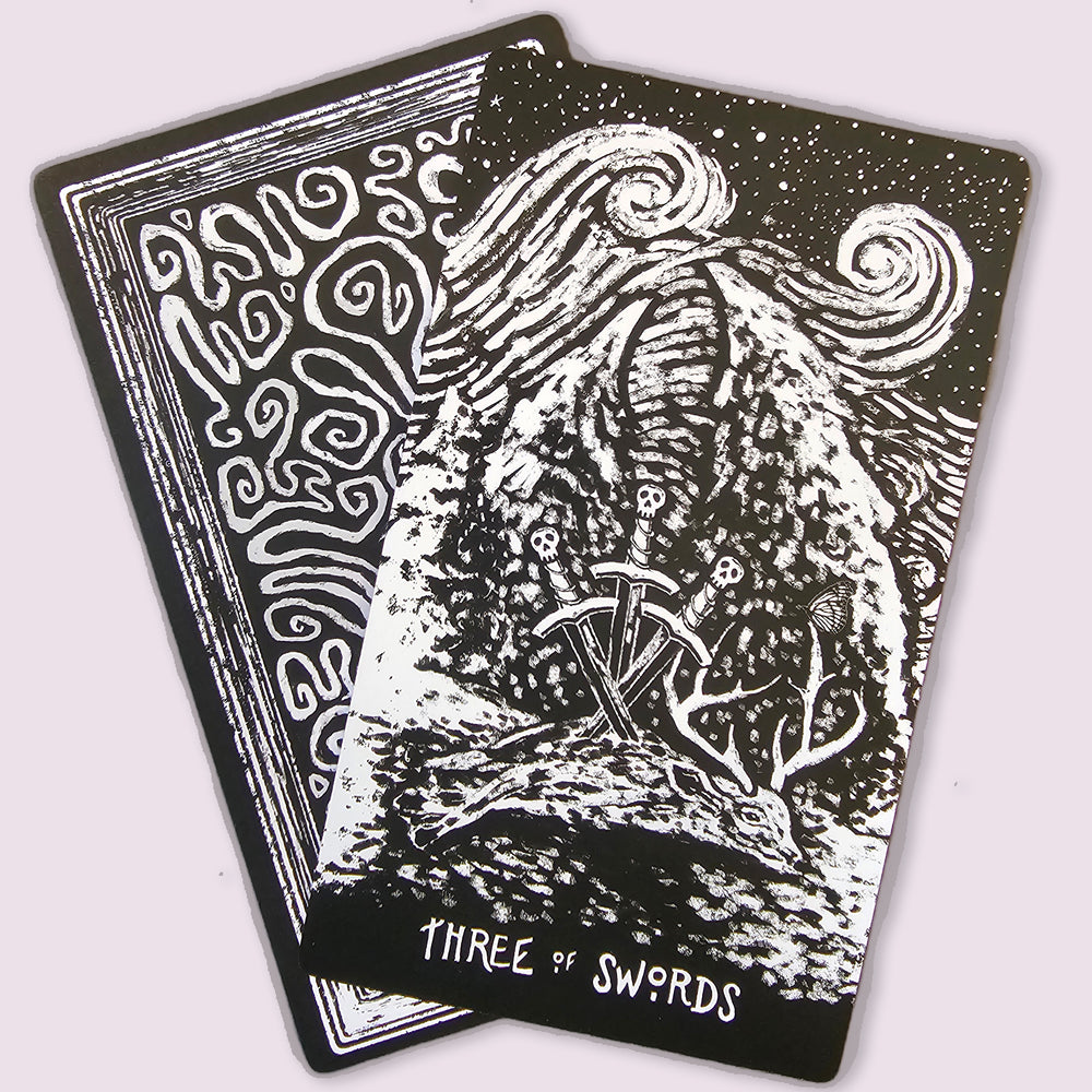 Night Visions Tarot Three of Swords card illustrated with crossed swords beneath a stormy night sky